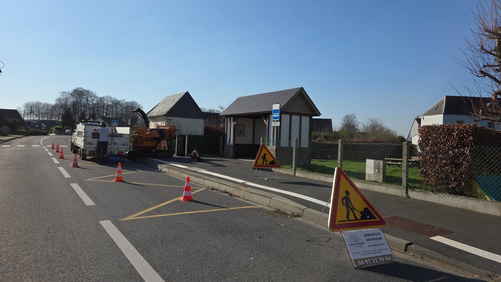 Chantier d'entretien signalé en bord de route : broyeur et remorque en place